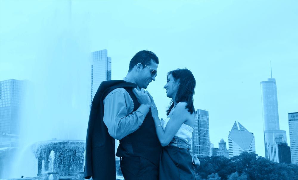Couple posing with a city skyline behind them