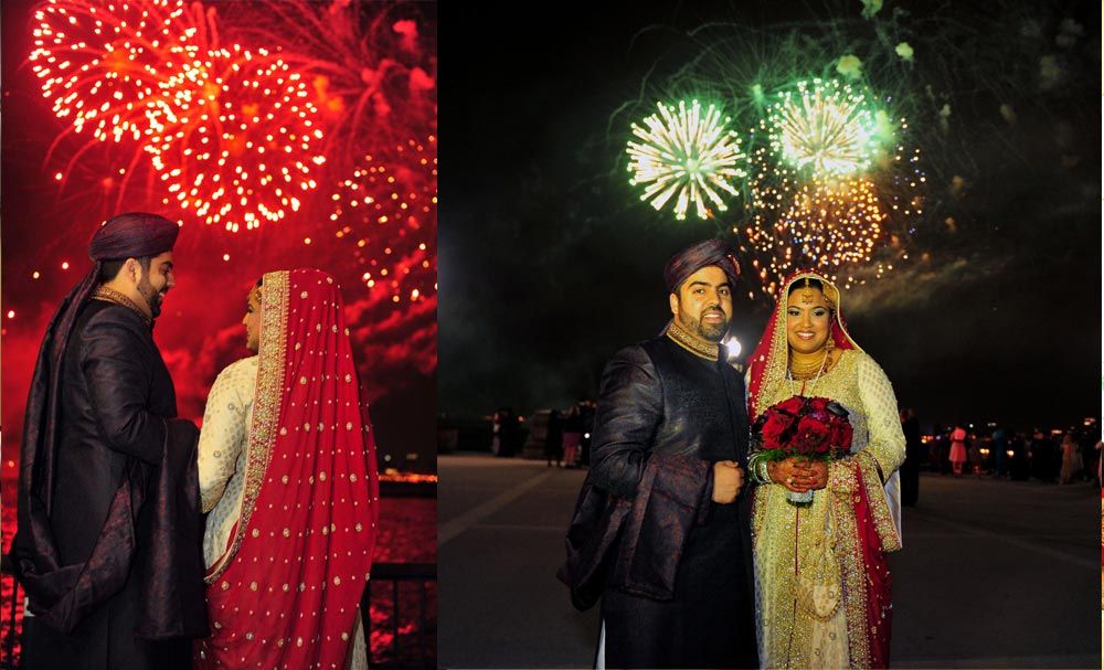 Bride and groom posing beneath evening fireworks