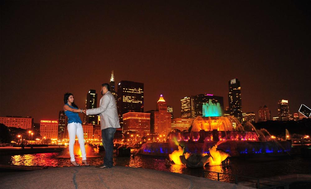 Couple posing against an illuminated city skyline