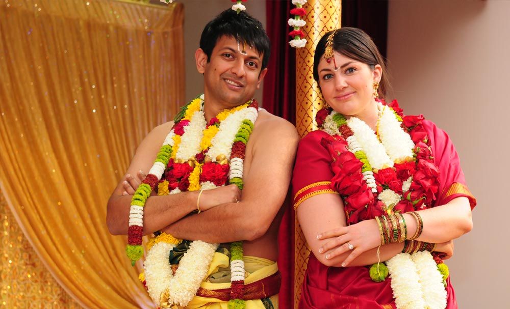 Newlyweds wearing flower garlands